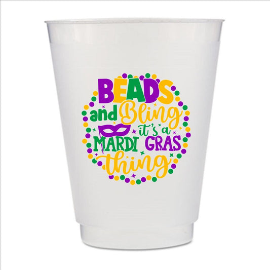 A white plastic cup with a colorful design featuring text and decorative elements related to Mardi Gras.